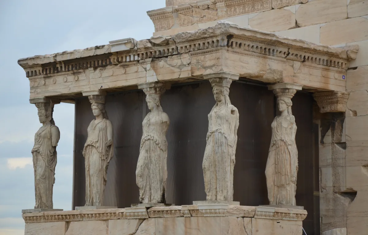 The Caryatid Porch of the Erechtheion on the Athenian Acropolis: six draped female figures carrying the entablature in place of columns, in raking light