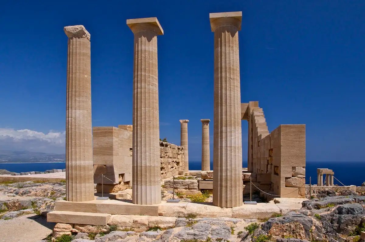 Doric columns of the Temple of Athena Lindia on the acropolis of Lindos, Rhodes, against a deep blue sky