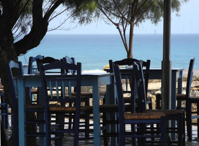 A taverna table set for two with a view over the sea