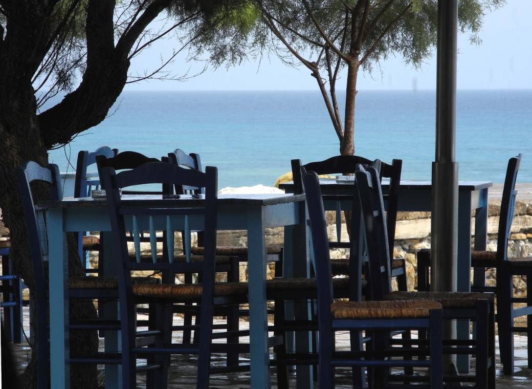 A taverna table set for two with a view over the sea