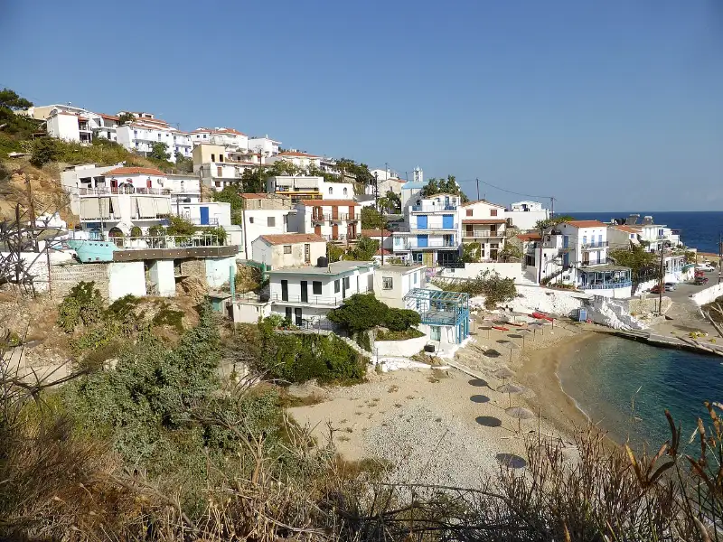 The village of Armenistis on the north coast of Ikaria, whitewashed houses stacked up the hillside above a small sandy cove
