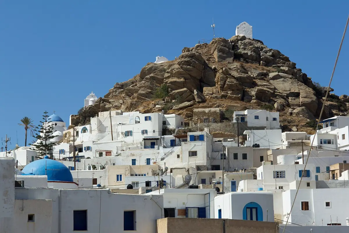 The Kastro rock above Chora of Ios, a bare granite dome topped with whitewashed chapels, with the white cubic town climbing to its foot