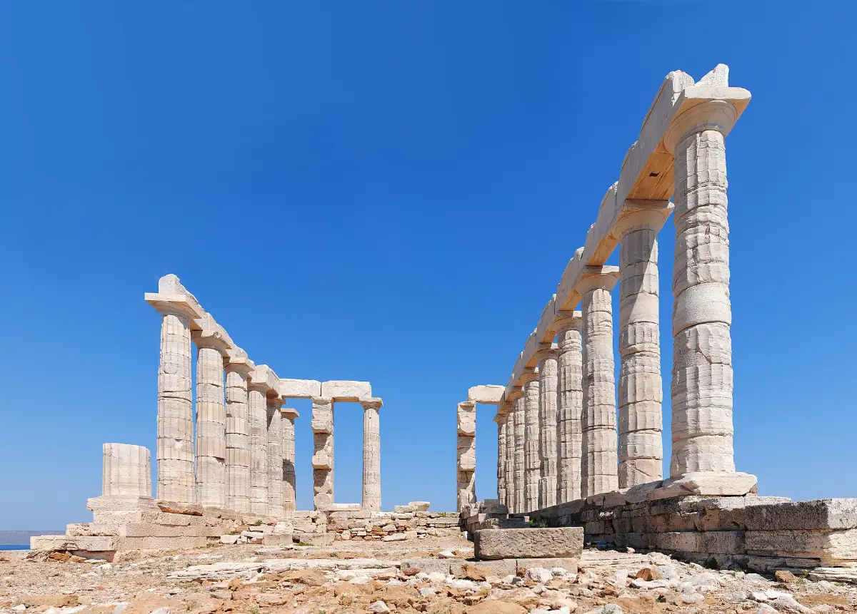 The marble columns of the Temple of Poseidon at Cape Sounion standing against a clear blue sky