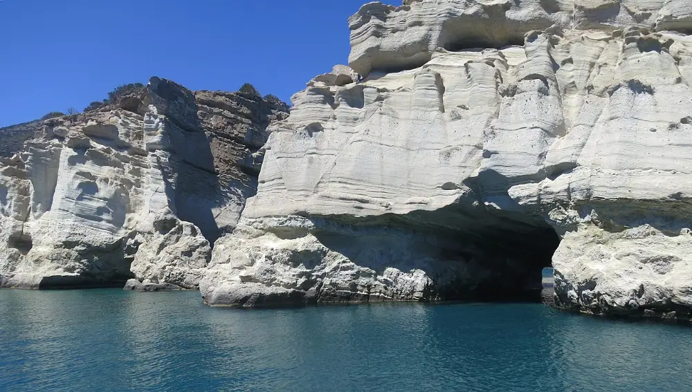 A white volcanic rock arch at Kleftiko, Milos, standing over deep clear water