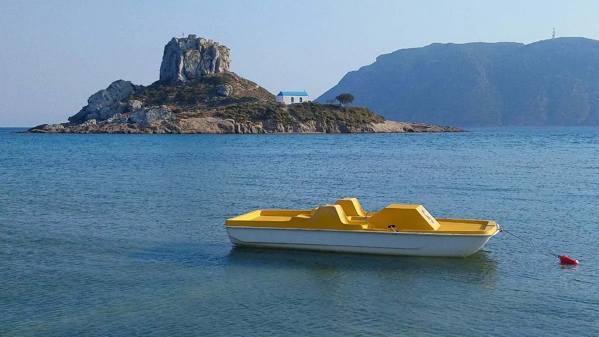 The islet of Kastri off Agios Stefanos on Kos, a rock stack with a small chapel, seen across the water