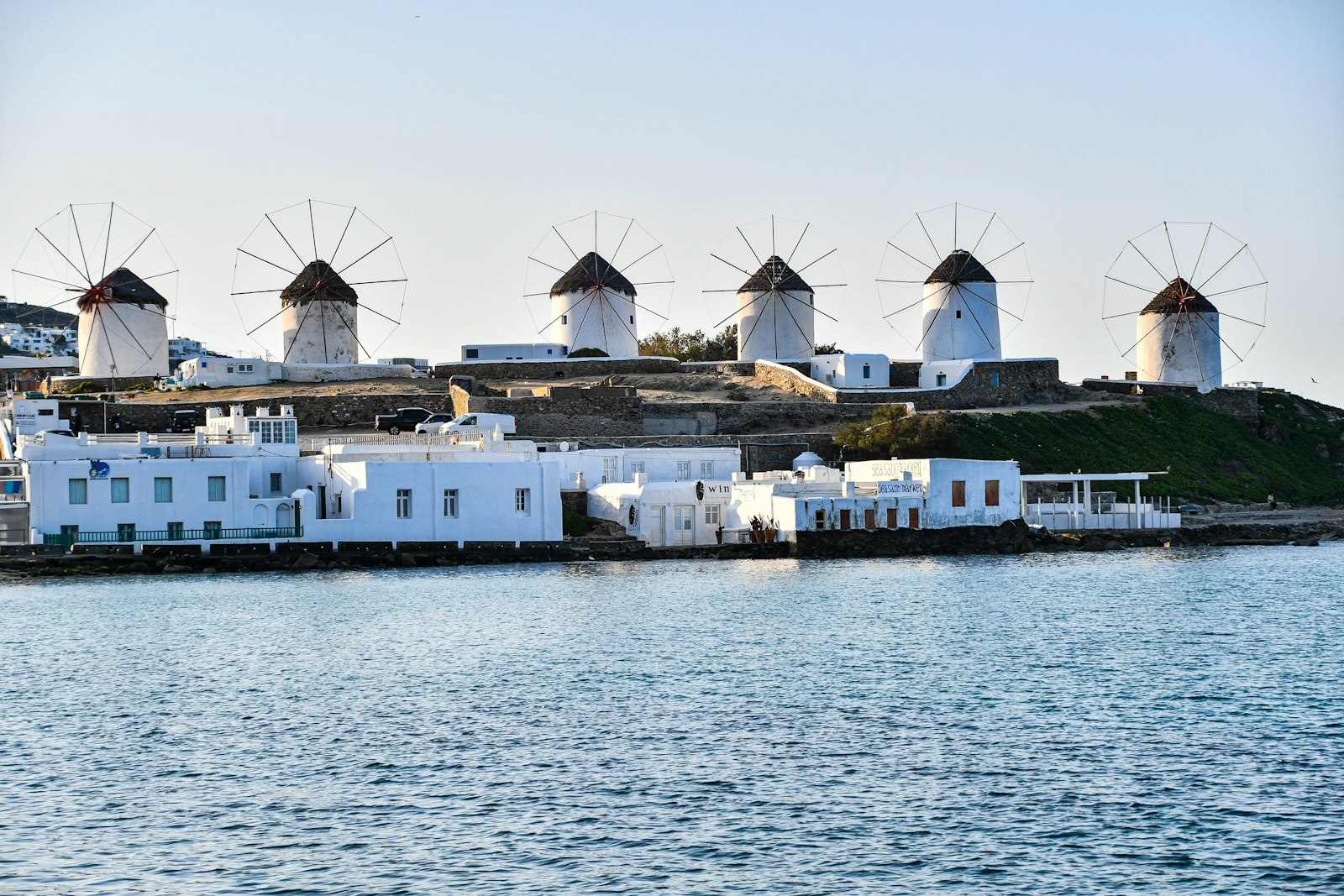 The Kato Mili windmills above Mykonos Town, with the whitewashed town and the Aegean behind.
