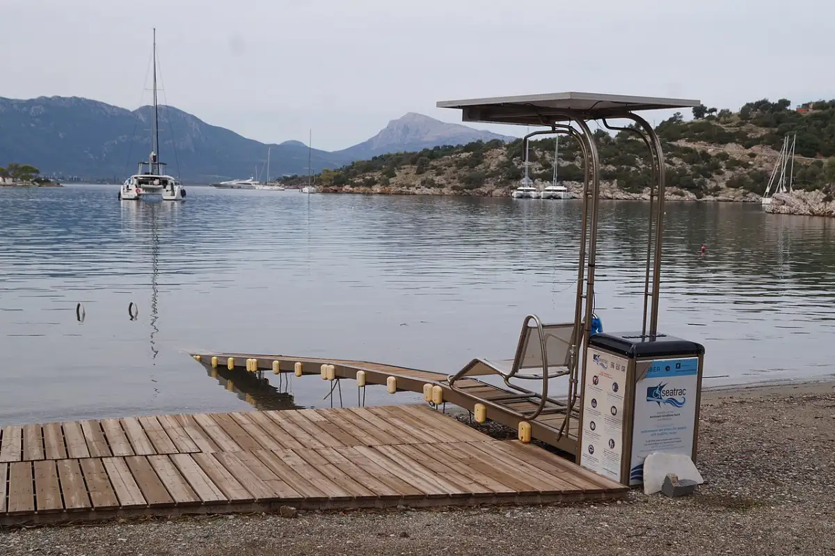 A Seatrac fixed rail and seat running from the sand into the sea on a Greek beach