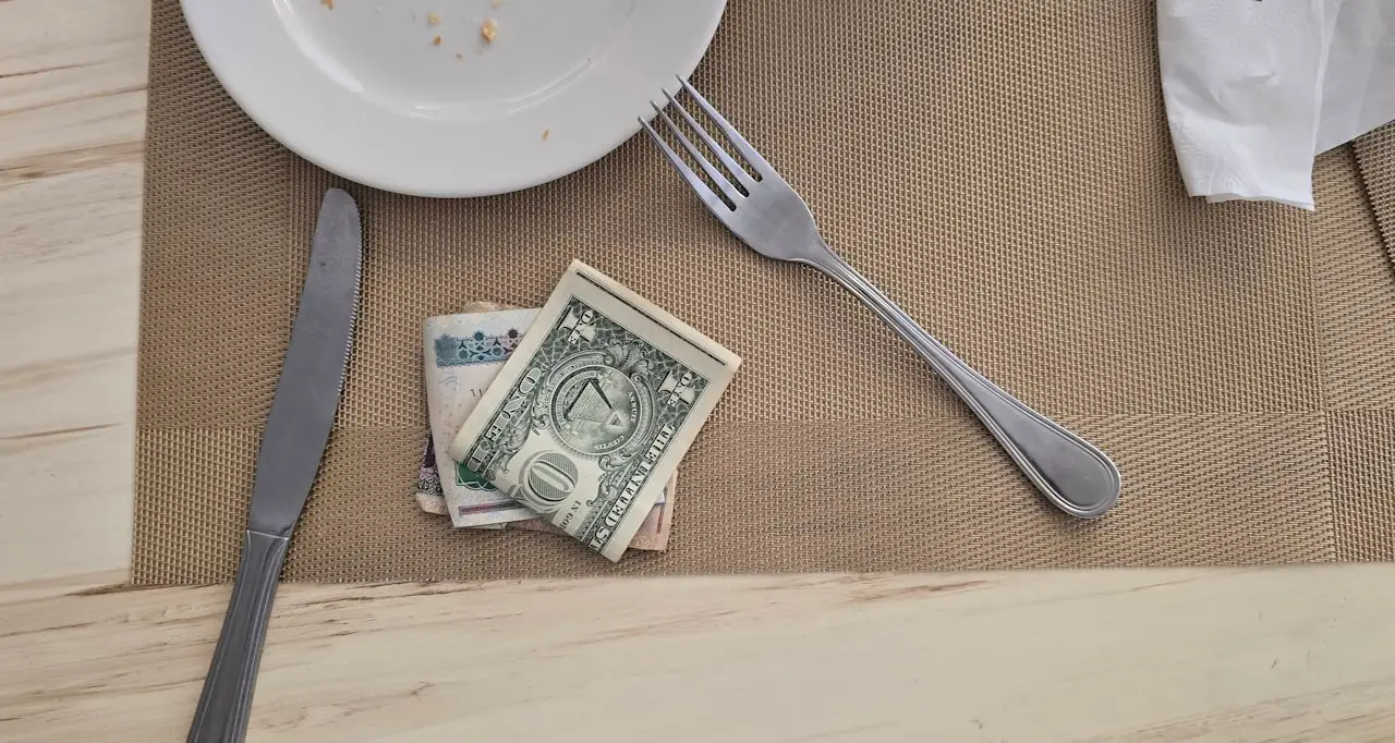 Notes and coins left on a table after a meal