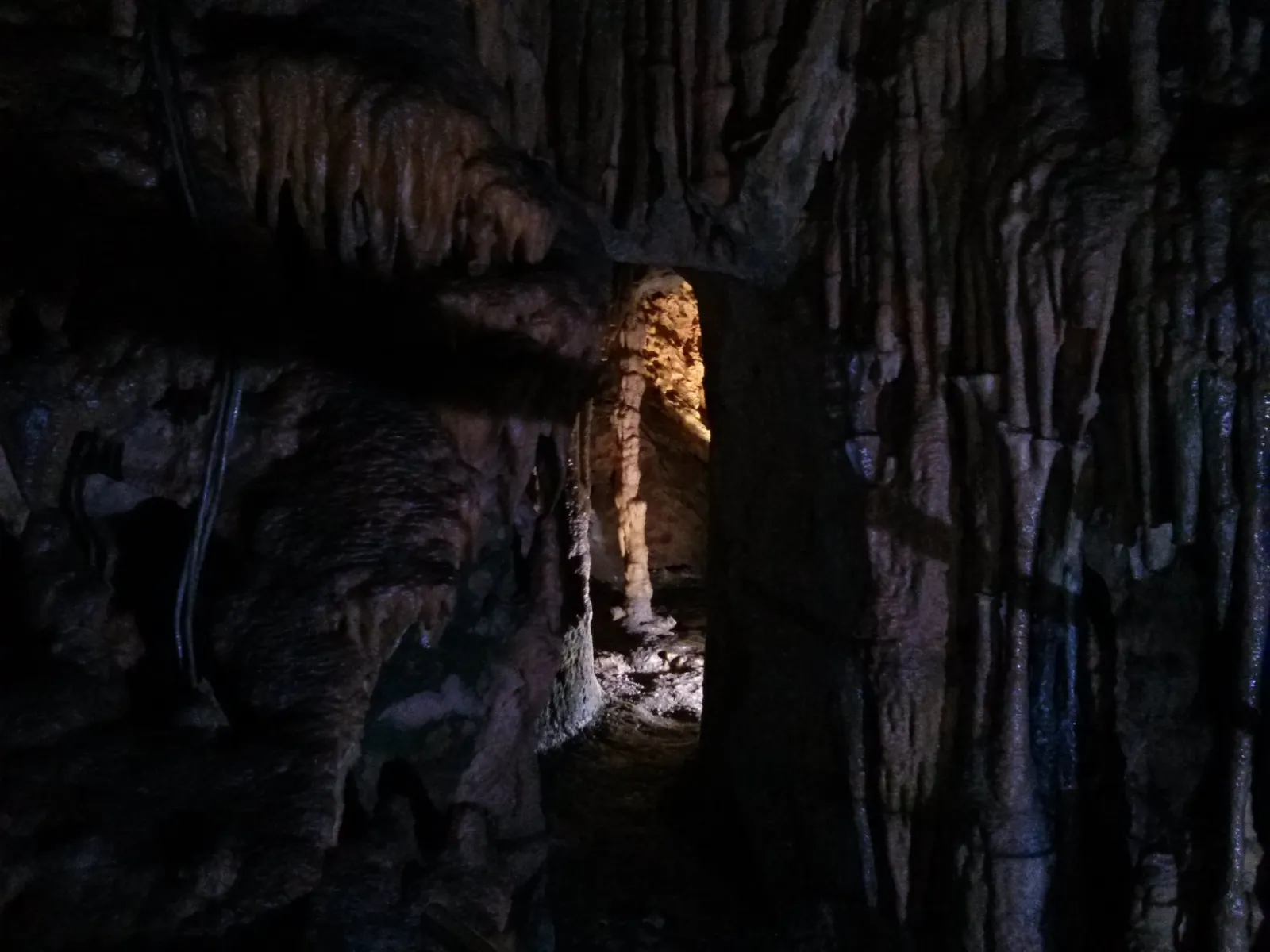 Illuminated rock formations inside the Diros caves