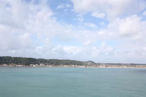 החוף החולי והשטוח בקאטאקולו תחת שמיים רחבים עם פסי עננים