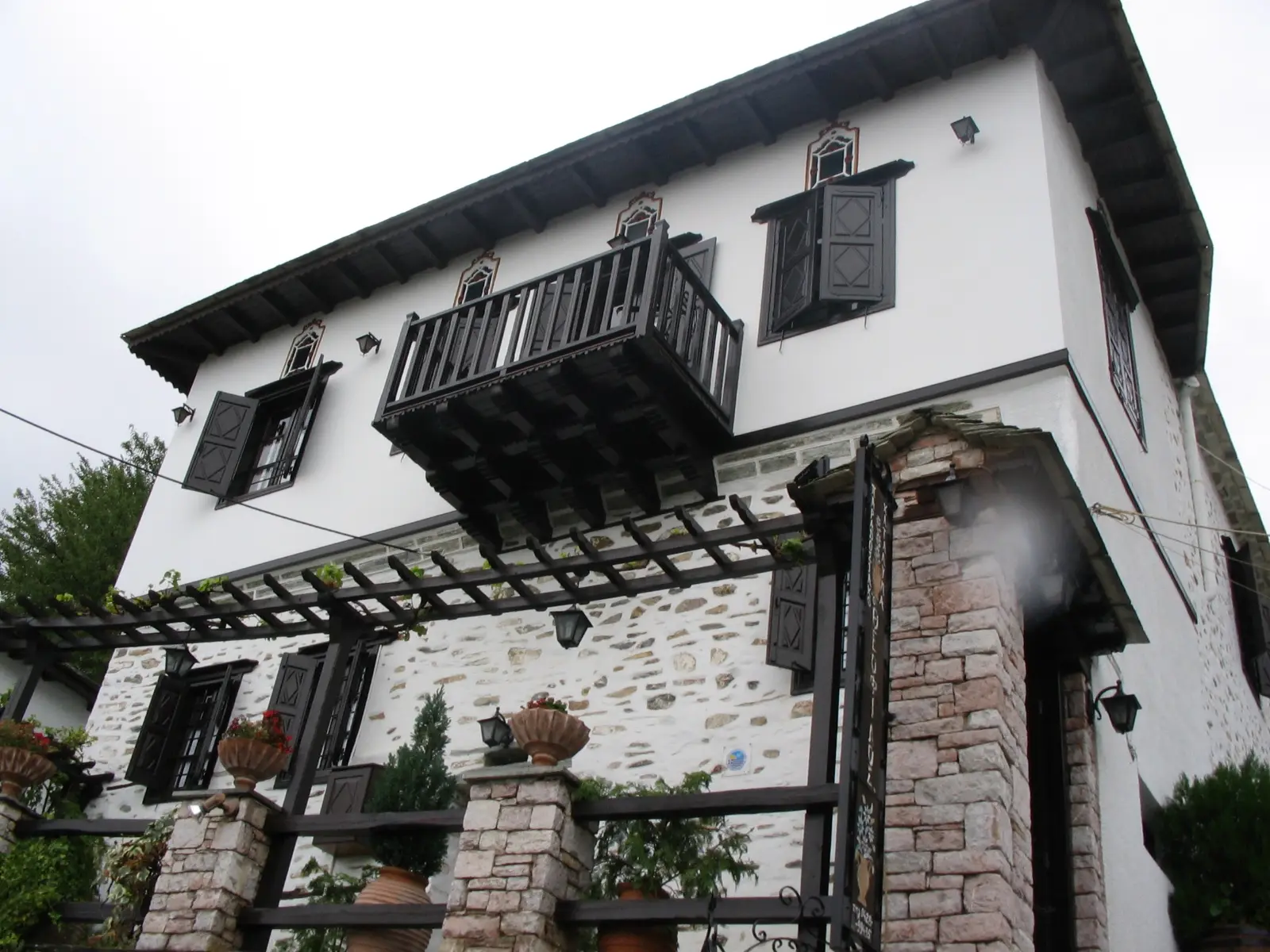 A stone and whitewashed Makrinitsa mansion with timber balconies and shutters