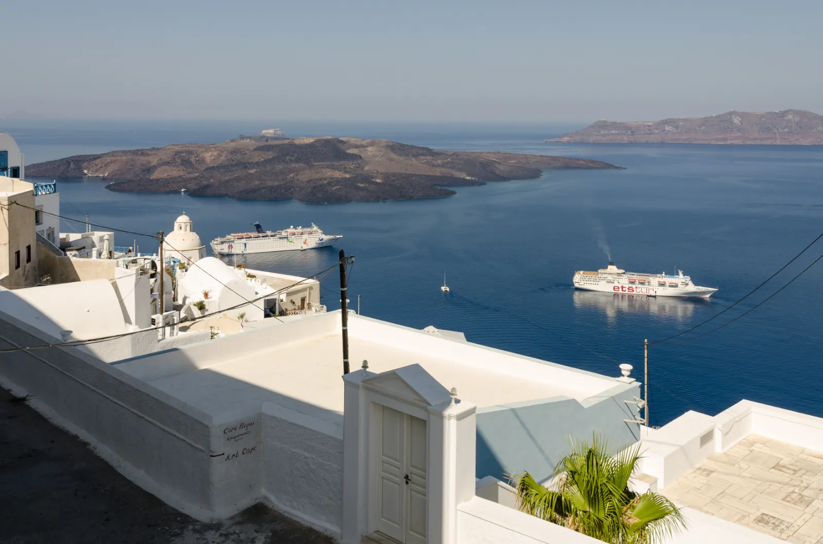 The Santorini caldera from Fira, boats crossing towards Nea Kameni
