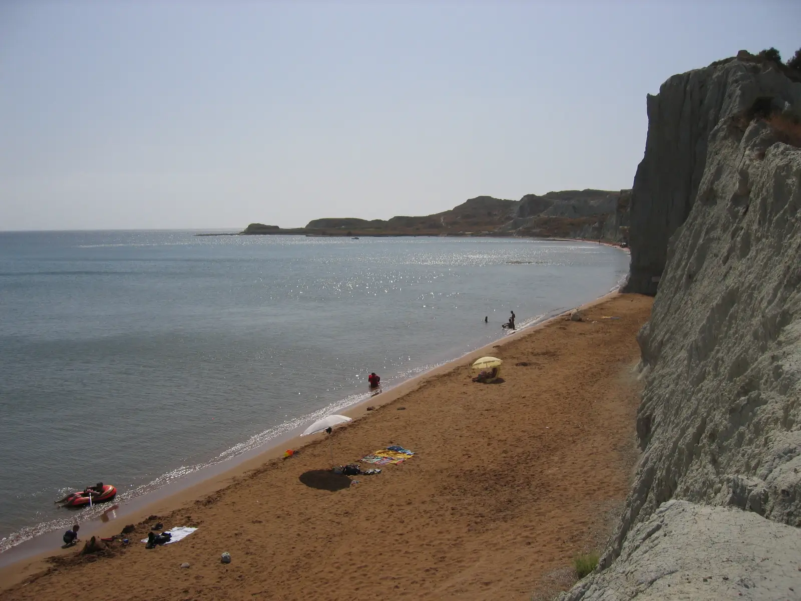 Xi beach on Kefalonia, red clay cliffs above dark sand