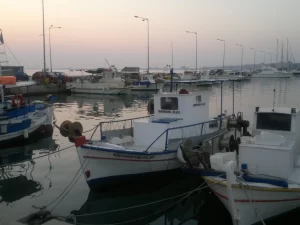 סירות דייגים עוגנות בנמל של קיליני עם שחר, והמרינה ושמיים חיוורים מאחוריהן