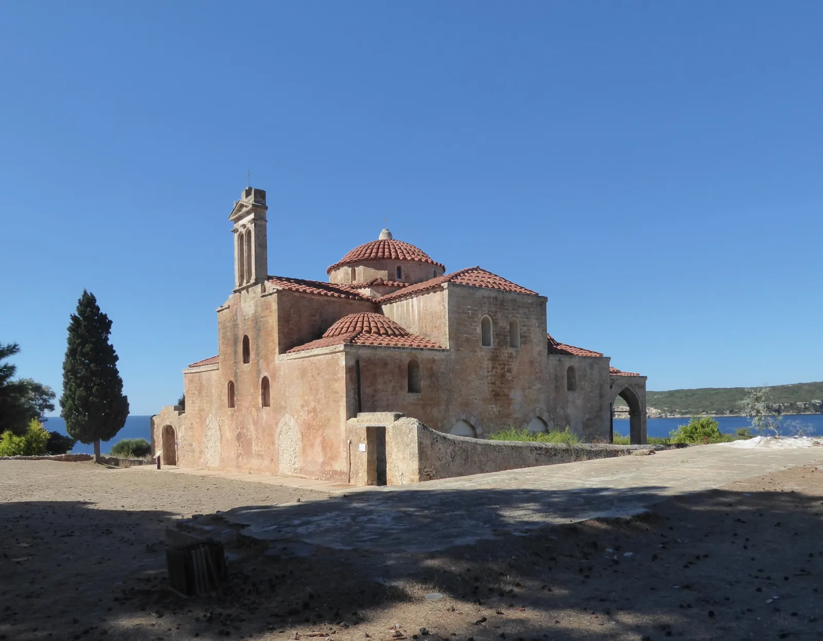 The church-mosque inside the Niokastro fortress at Pylos, a domed stone building with tiled roofs standing on open ground above the bay